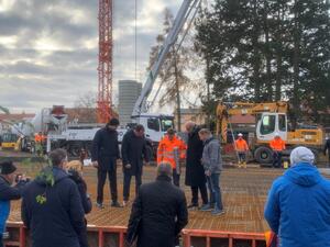 Die Zeitkapsel wird durch Herrn Aster in das Fundament eingelassen.